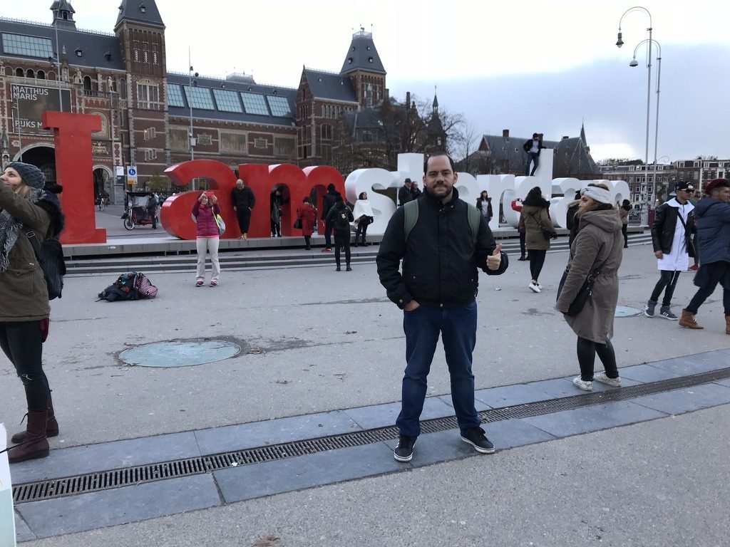 Tiago Lopes à beira de um canal, com a Basílica de São Nicolau ao fundo