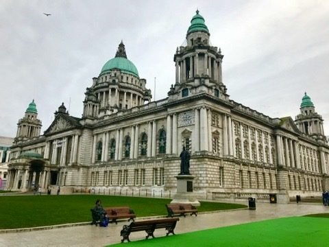 Fachada da Belfast City Hall, com cúpulas verdes, vista do gramado