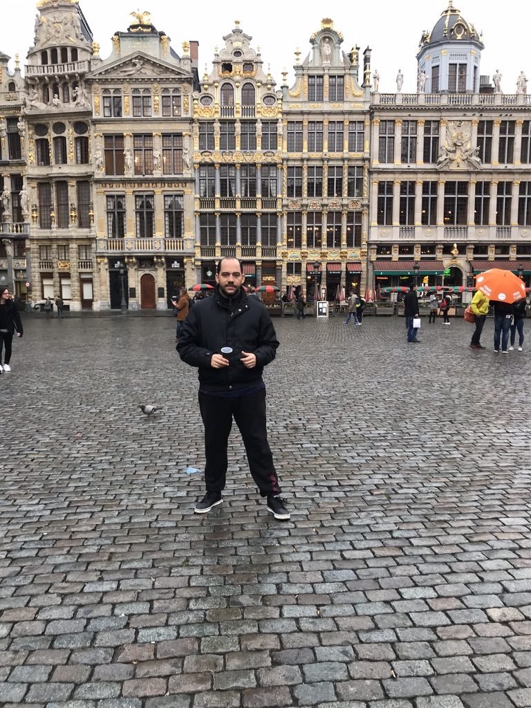 Tiago Lopes na Grand-Place de Bruxelas, com as fachadas douradas das casas das corporações ao fundo