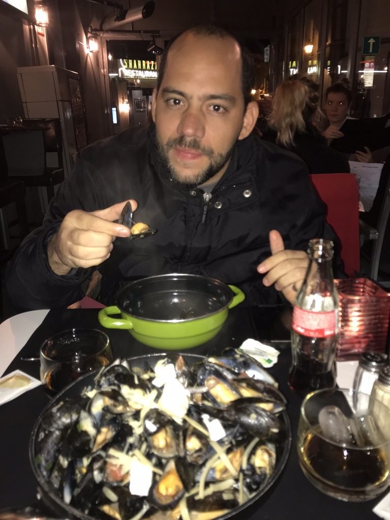 Tiago Lopes comendo mexilhões em um restaurante
