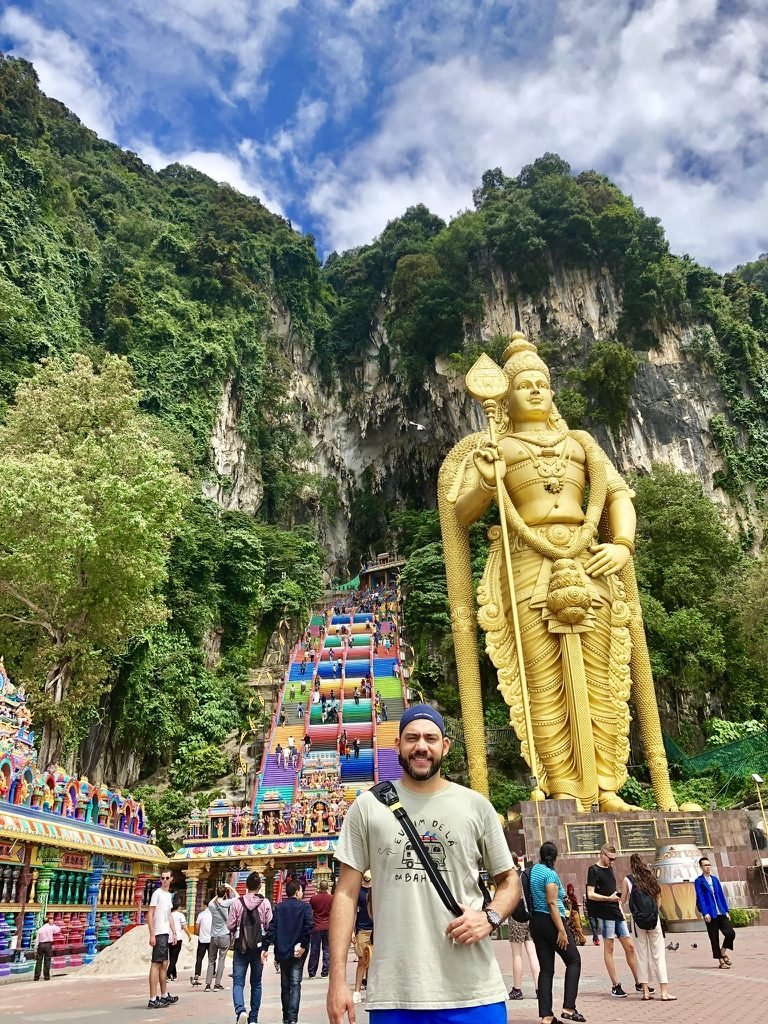 Tiago Lopes nas Batu Caves, com a estátua dourada e a escadaria colorida