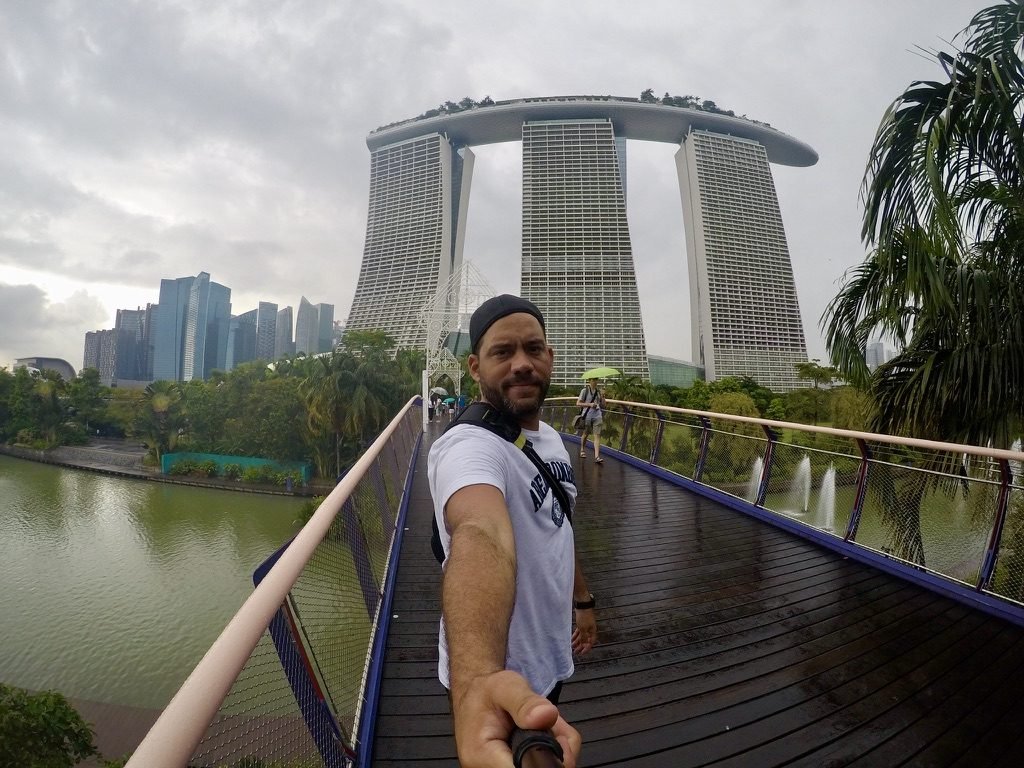 Tiago Lopes em selfie numa passarela, com o hotel Marina Bay Sands ao fundo